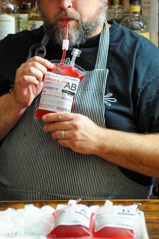 Man holding iv bag with red cocktail inside