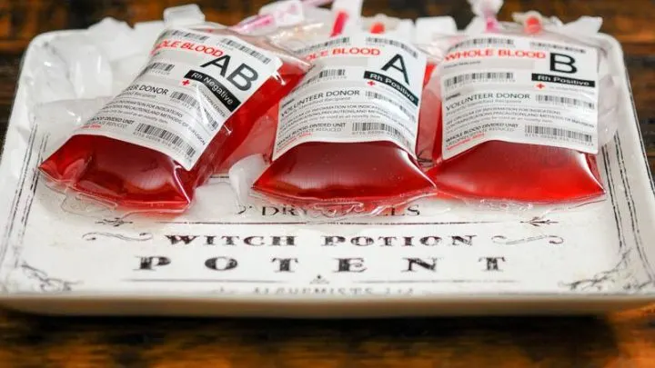 Iv bags filled with red cocktails, on white platter