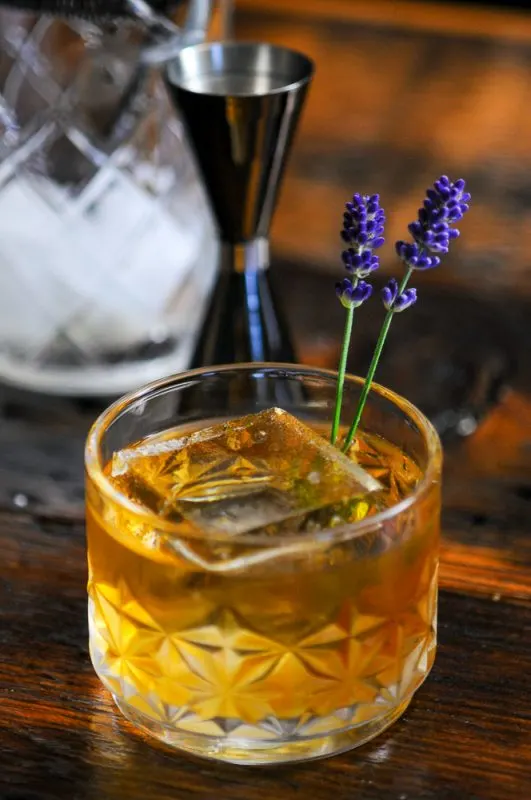 whiskey cocktail in rocks glass with lavender sprigs