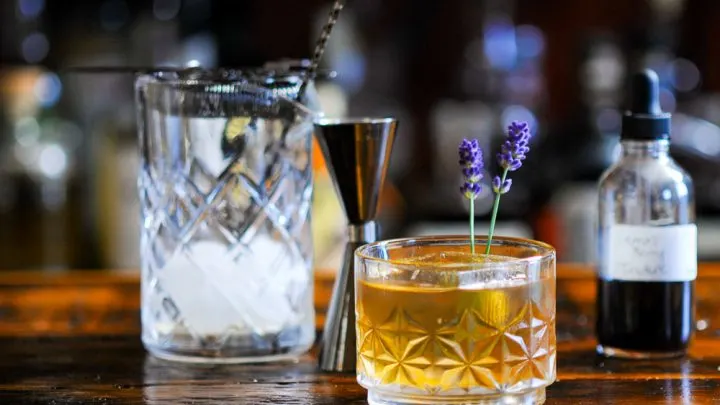 whiskey cocktail in rocks glass, lavender sprigs