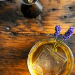 Top shot of whiskey cocktail in rocks glass with lavender sprigs