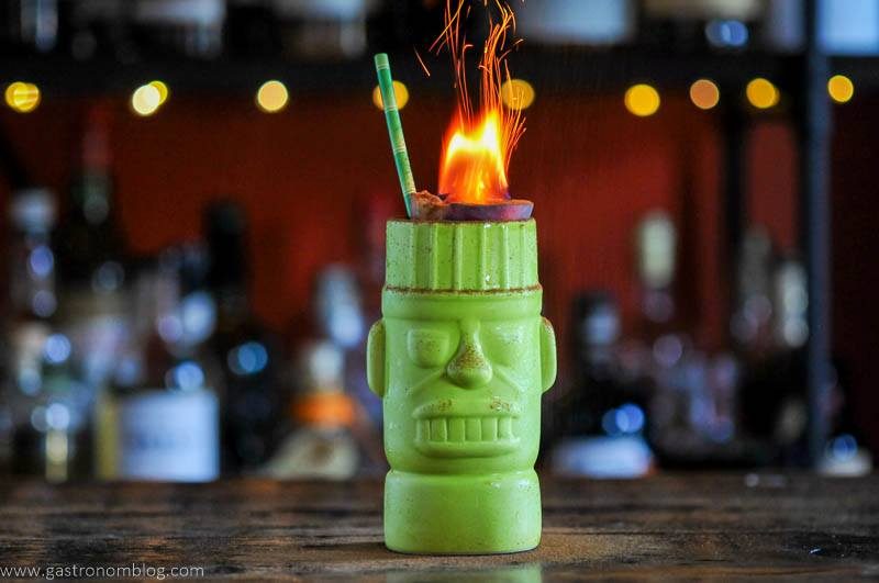 Green tiki mug with flames and a straw