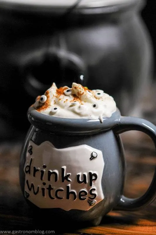 Gray cauldron cocktail for Halloween, whipped cream and eye candies