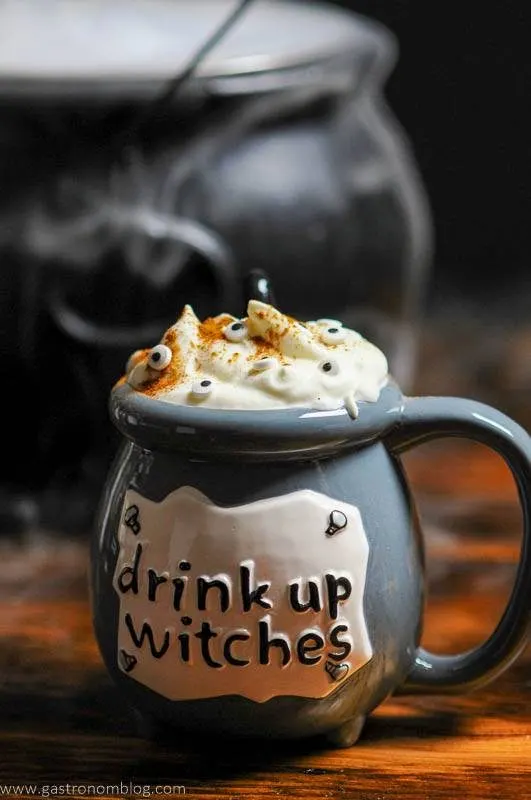 Witch cauldron with Halloween Cocktail, topped with whipped cream and eye candies