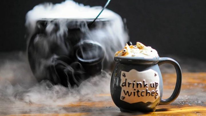 Gray cauldron with cocktail, topped with whipped cream for Halloween