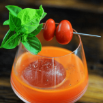 Top shot of orange cocktail, tomatoes and basil