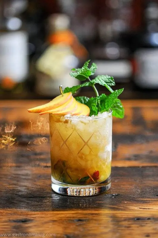 Peach Mint Julep Cocktail in frosted gold etched glass, mint and peach slices