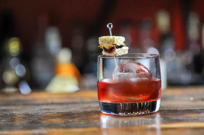 Peanut Butter and Jelly Cocktail in rocks glass, tiny PB & J sandwich garnish