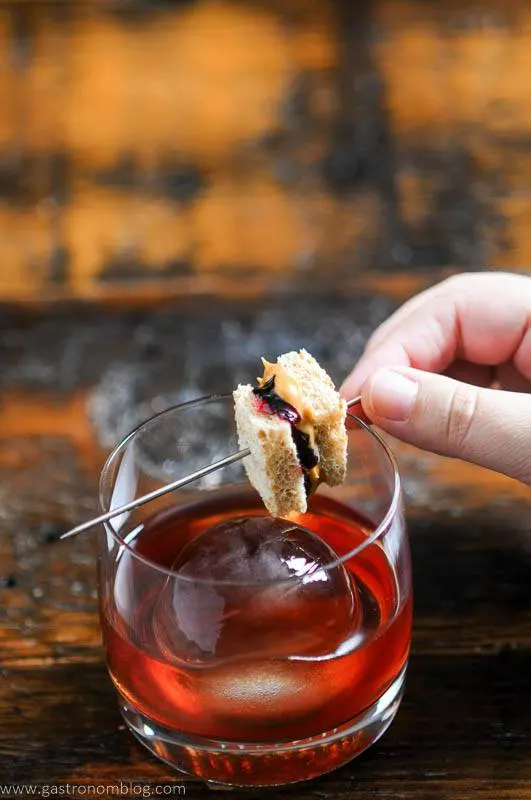 Peanut Butter and Jelly Cocktail in rocks glass, tiny PB & J sandwich garnish