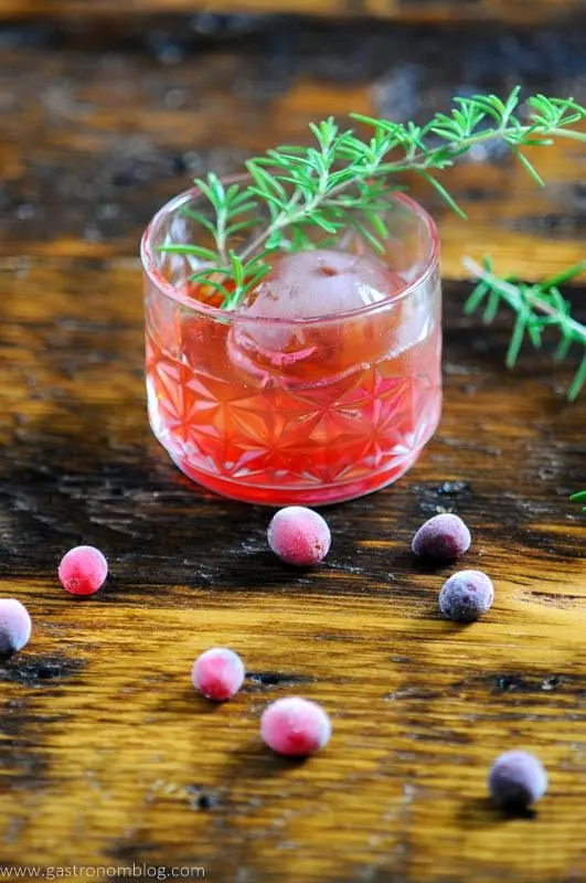 Red cocktail with cranberries and rosemary