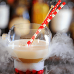 Tan cockatil with white foam in ornament glass, dry ice smoke and red/white straws