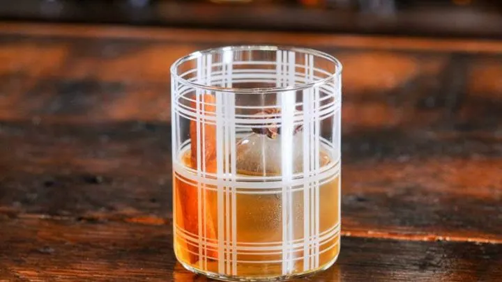 Striped rocks glass with whiskey cocktail