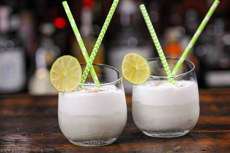 Coconut Lime Cocktail in glass with lime and straw