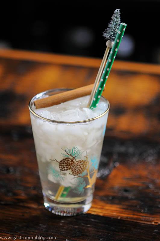 Gin and Tonic in pine glass, green straw