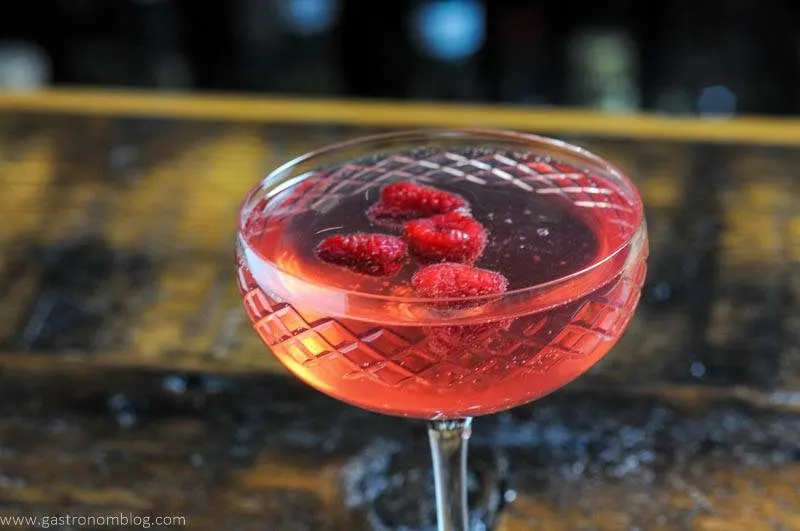 pink cocktail in coupe with raspberries