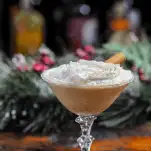 Brown cocktail in coupe with whipped cream