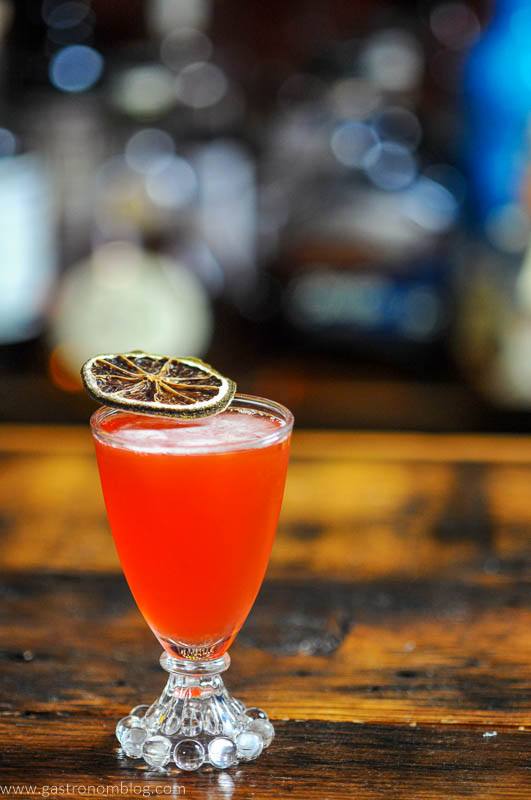 Pink cocktail with citrus slice garnish