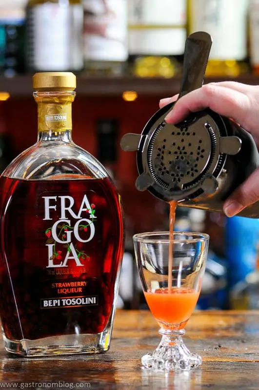 Strawberry cocktail being poured into glass