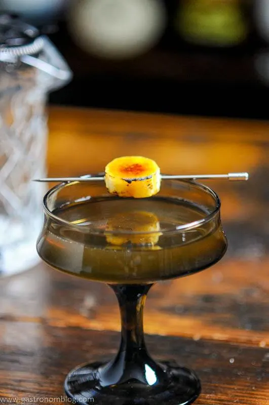 Brown cocktail glass with banana garnish