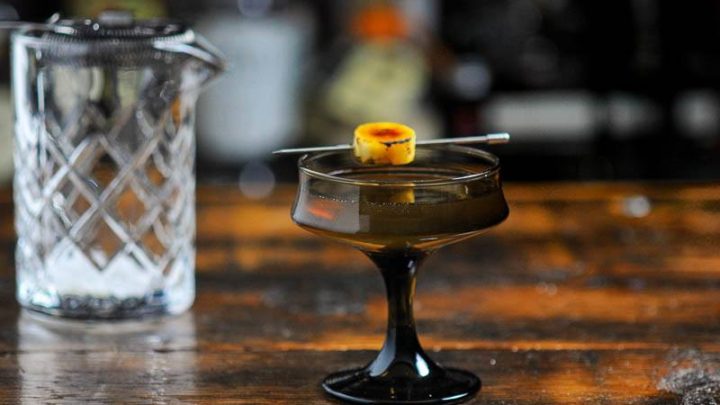 Коктейльный бокал из коричневого стекла с коктейлем из виски