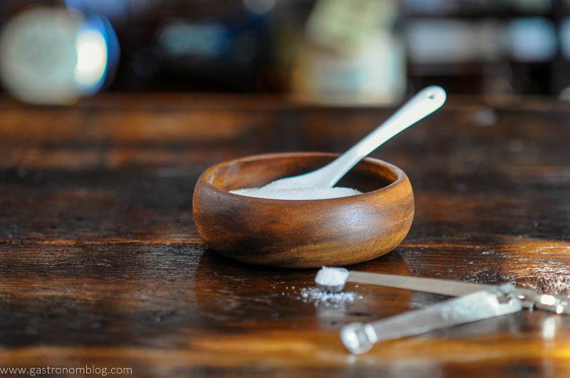 Bowl of sugar with white spoon, measuring spoons