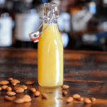 creamy yellow Almond syrup in bottle with almonds