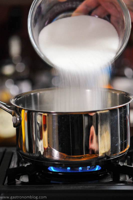 sugar being poured into saucepan