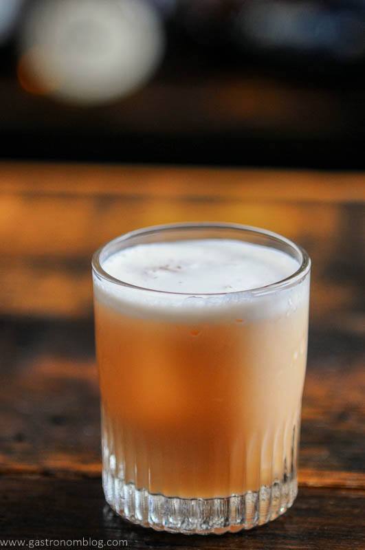 Peach colored cocktail with egg white foam