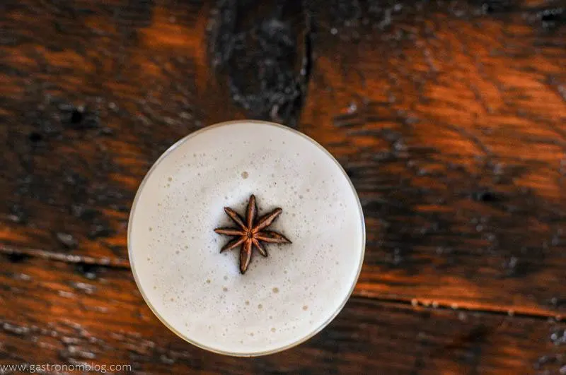 Top shot of egg white whiskey sour cocktail with star anise on foam
