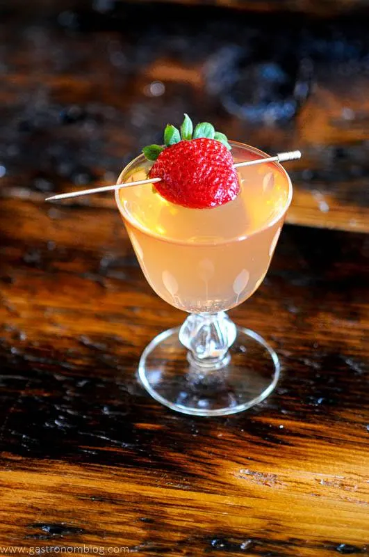 Strawberry on pick in glass cocktail, wood background