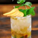 Peach Mint Julep Cocktail wtih peach slices and mint