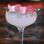 Pink cocktail in coupe with rhubarb garnish