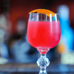 Hot Pink raspberry margarita cocktail in glass with orange peel
