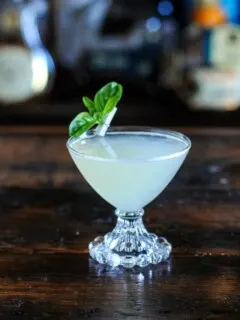 Basil gimlet in cocktail coupe with basil leaves