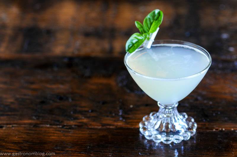 Basil gimlet in cocktail coupe with basil leaves