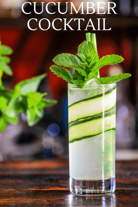 Tall glass with cucumber slices in glass, topped with mint