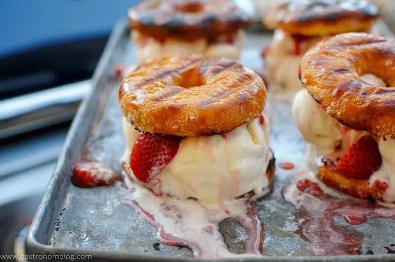 Melting Ice Cream sandwich on cookie sheet with strawberries