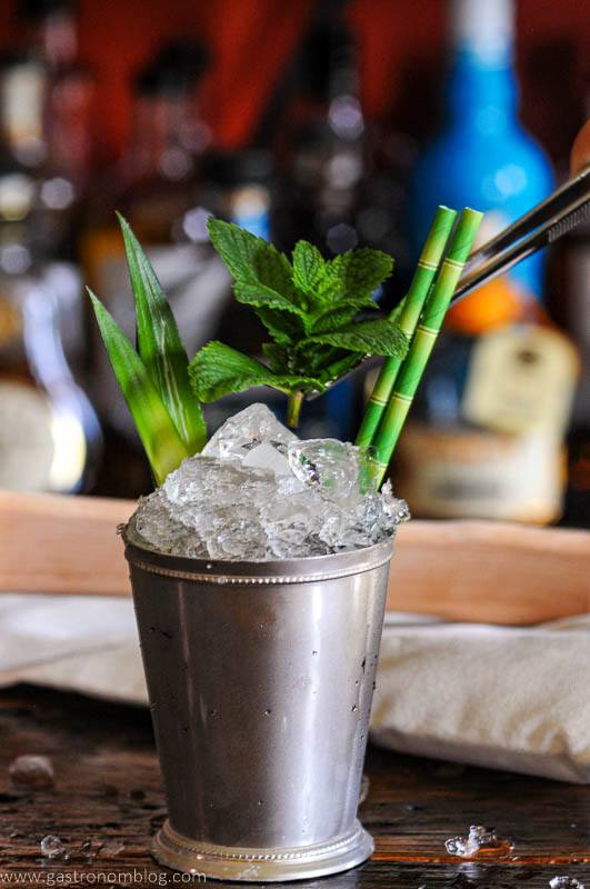 Silver cup cocktail, crushed ice, green straws, mint sprig and pineapple fronds