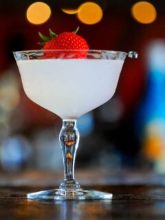 Opaque cocktail in coupe, strawberry on pick