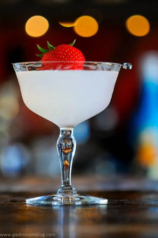 Opaque cocktail in coupe, strawberry on pick