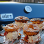 Grilled doughnuts with ice cream in between, on a cookie sheet outside