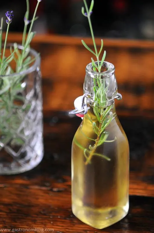 Lavender Syrup in bottle, lavender sprigs in glass in background