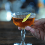 Brown cocktail in coupe with lemon peel