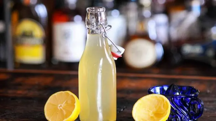 Yellow syrup in bottle with lemons