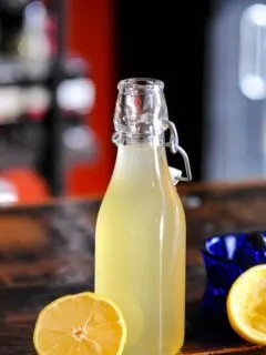 Yellow syrup in bottle with lemons