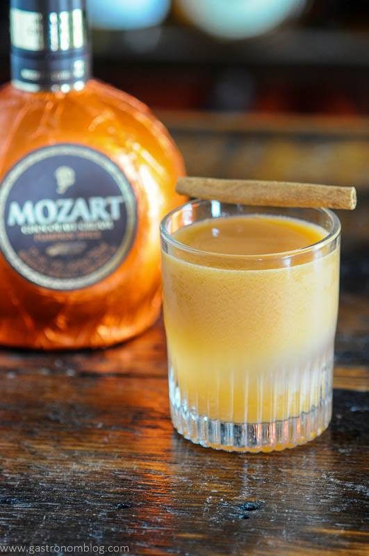 Orange cocktail in rocks glass, orange liqueur bottle behind