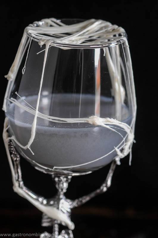 Gray cocktail in skeleton glass with marshmallow sprider webs