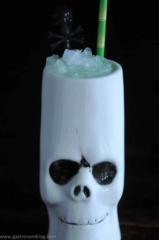 Skull tiki mug with green bamboo straw and skull pick
