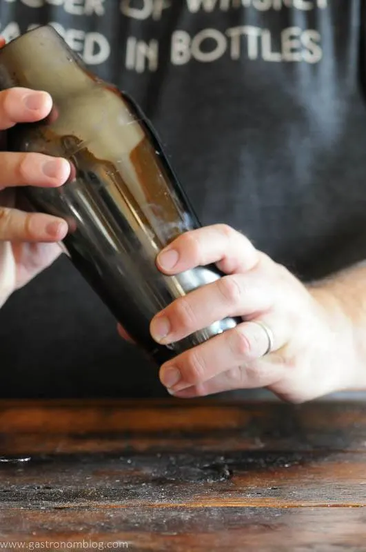 shaking a cocktail in a silver cocktail shaker