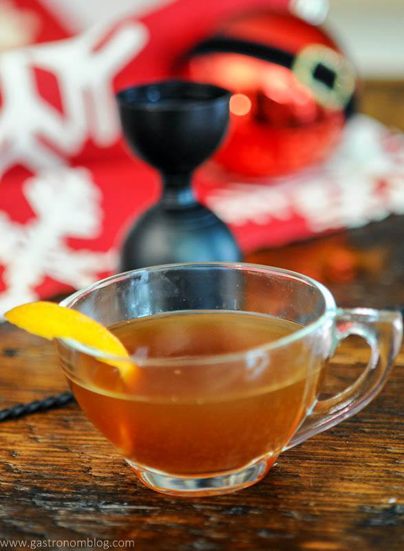 tan cocktail in a teacup, orange zest
